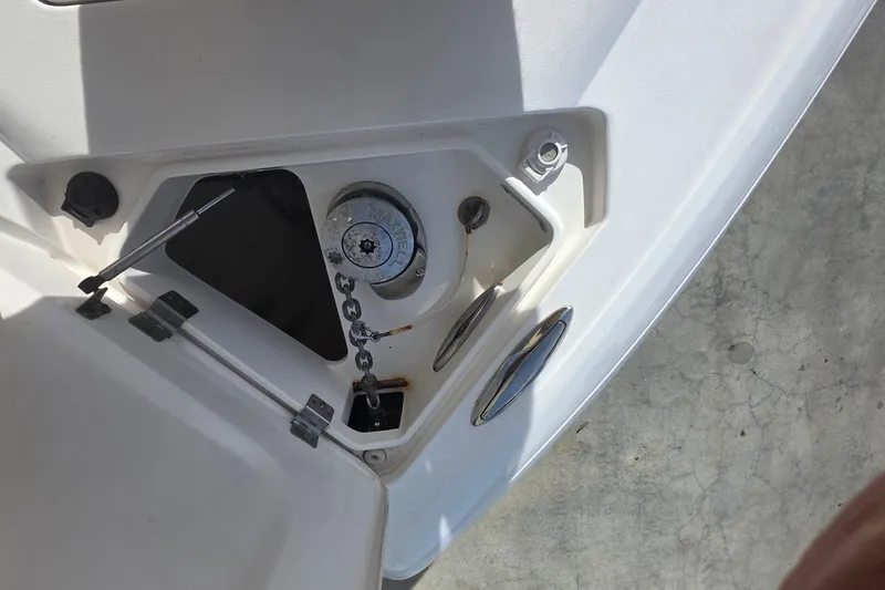 Slide: The Image of Anchor compartment of 2015 Intrepid 327 Center Console boat, featuring chain and winch. - 14