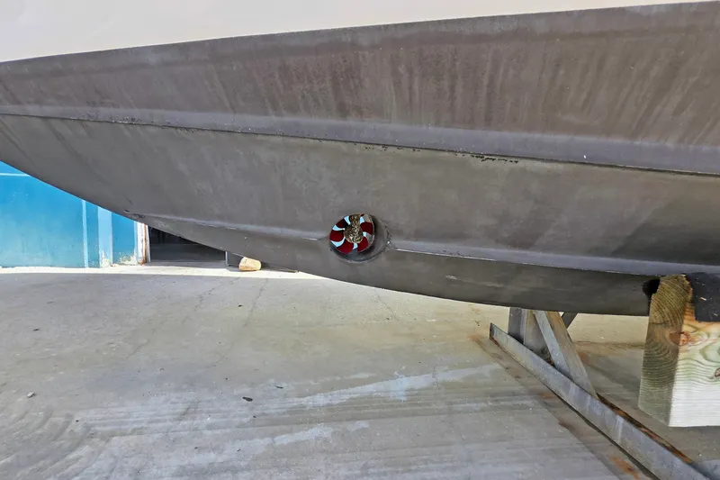 Slide: The Image of 2015 Intrepid 327 Center Console boat hull with visible thruster on dry dock. - 34