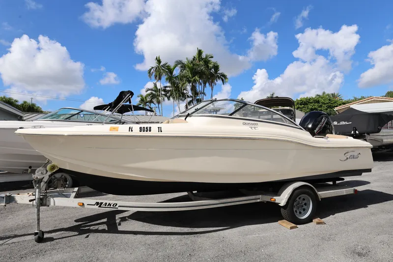 Slide: The Image of 2023 Scout 210 Dorado boat on trailer under blue sky with clouds. - 1