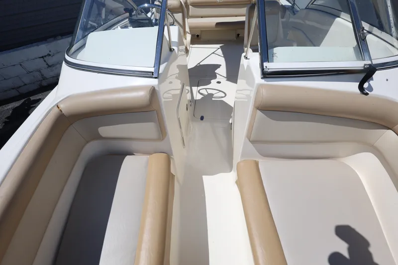 Slide: The Image of 2023 Scout 210 Dorado boat interior with beige seating and dual windshields. - 16