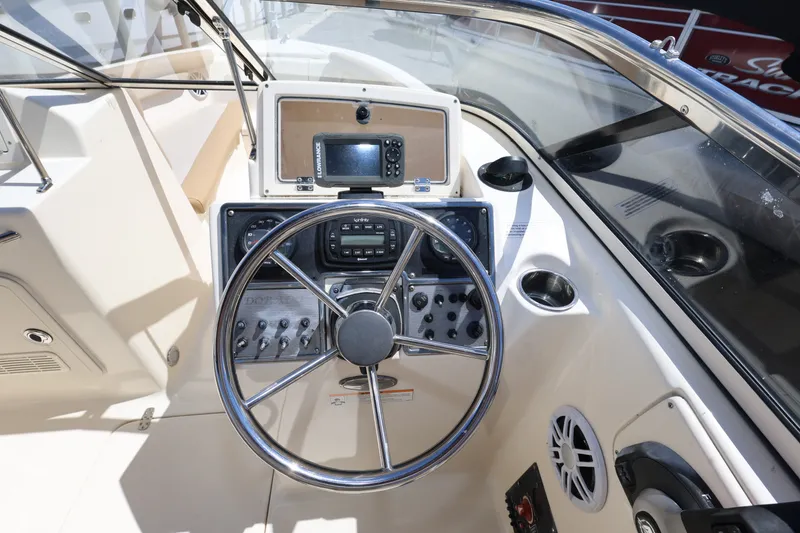 Slide: The Image of 2023 Scout 210 Dorado boat dashboard with steering wheel and navigation equipment. - 12