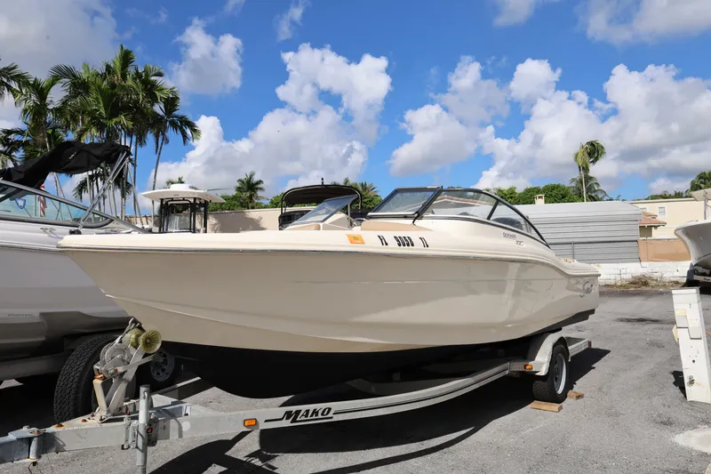 Slide: The Image of 2023 Scout 210 Dorado boat on trailer under clear blue sky. - 2