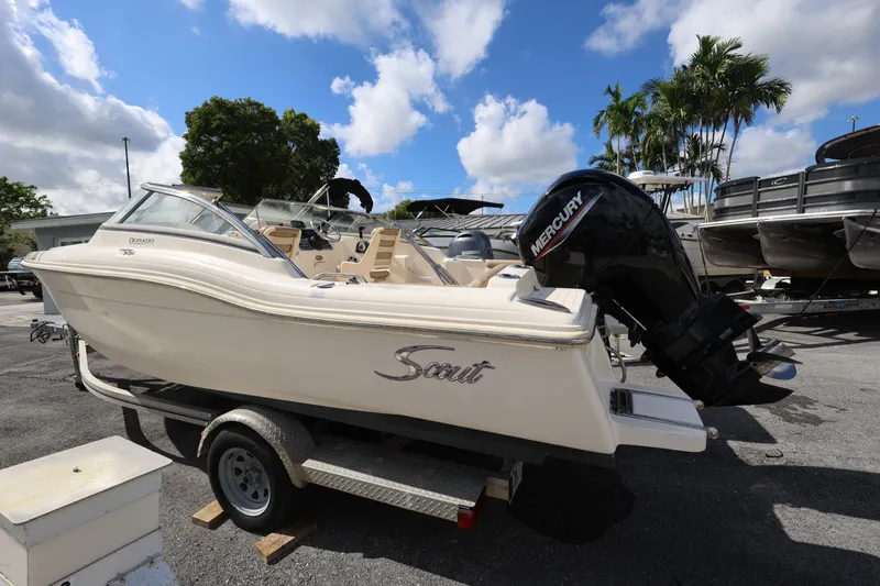 Slide: The Image of 2023 Scout 210 Dorado boat with Mercury engine on trailer, parked outdoors. - 4