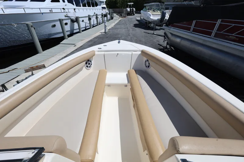 Slide: The Image of 2023 Scout 210 Dorado boat interior with beige seating at a marina. - 14