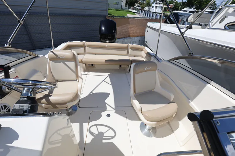 Slide: The Image of 2023 Scout 210 Dorado boat interior with beige seating and steering wheel. - 18