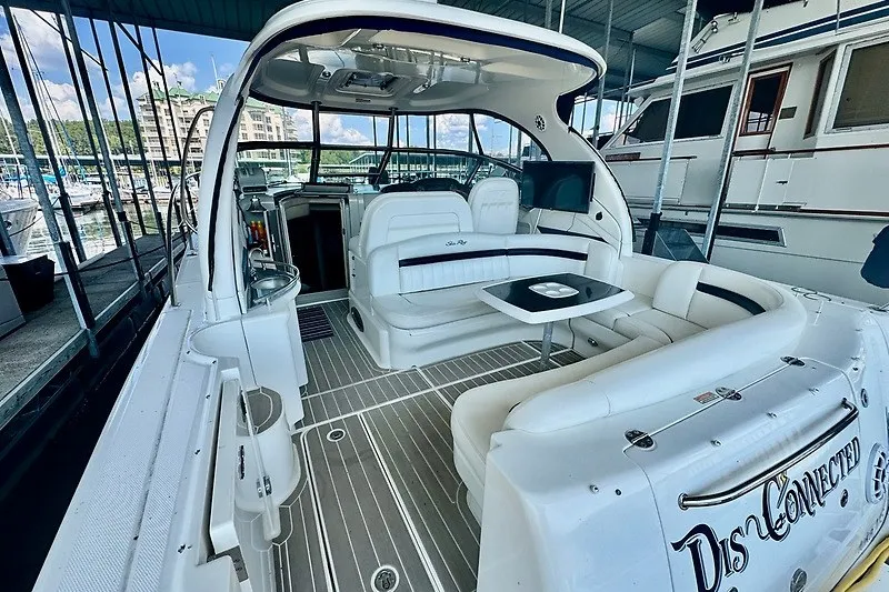 Slide: The Image of 2005 Sea Ray 390 Sundancer yacht interior with white seating and table in marina. - 27