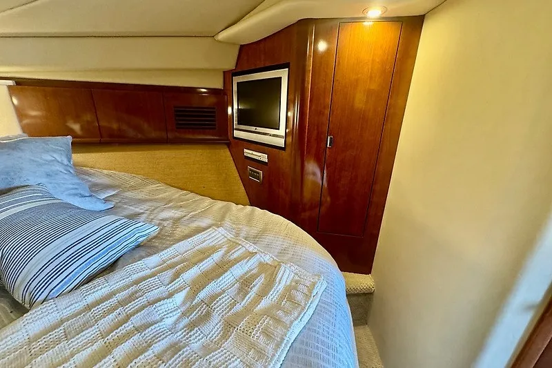 Slide: The Image of Luxurious cabin interior of 2005 Sea Ray 390 Sundancer with cozy bedding and wood paneling. - 15