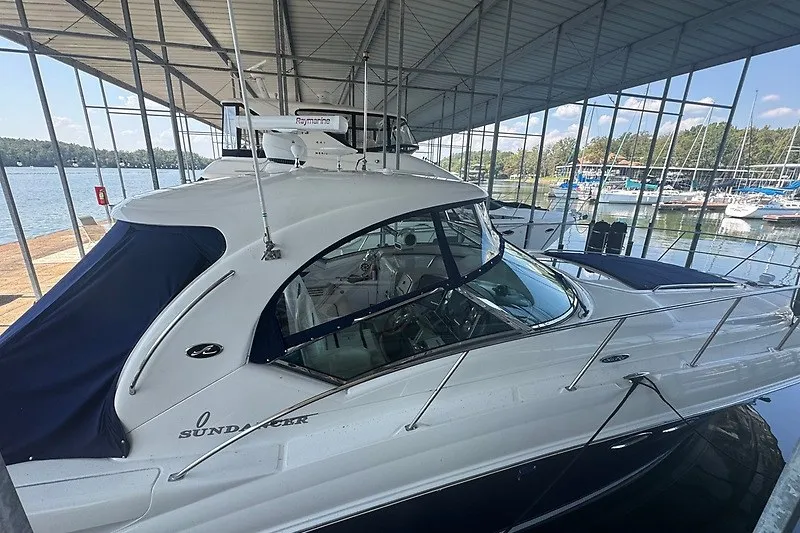 Slide: The Image of 2005 Sea Ray 390 Sundancer yacht docked in a marina under a covered structure. - 21