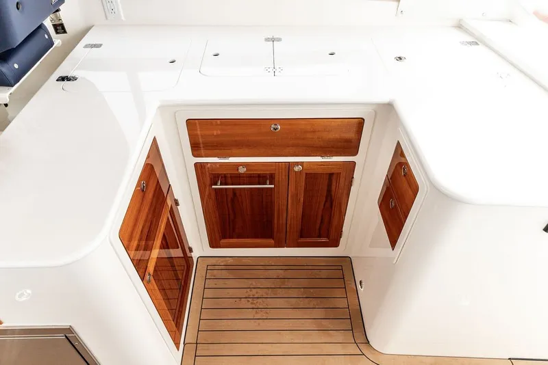 Slide: The Image of 2026 Hinckley Picnic Boat 39 interior with wooden cabinetry and sleek white surfaces. - 12