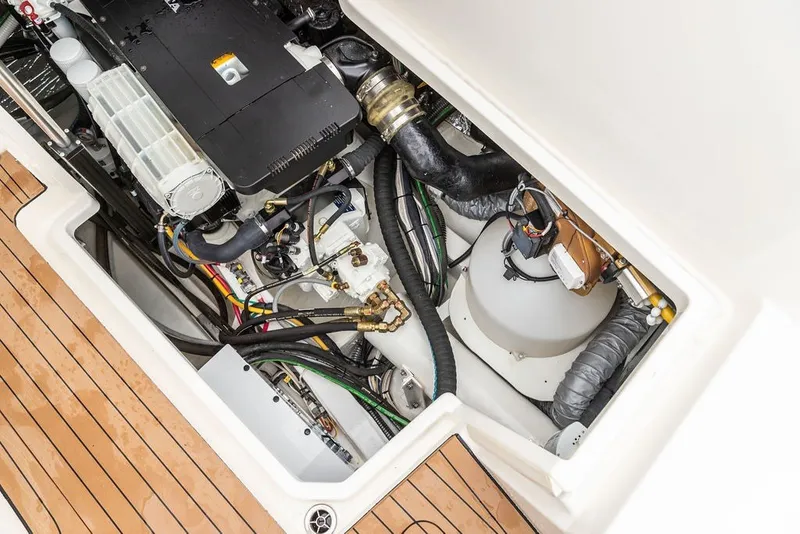 Slide: The Image of Engine compartment of 2026 Hinckley Picnic Boat 39, showcasing mechanical components and wooden deck. - 39