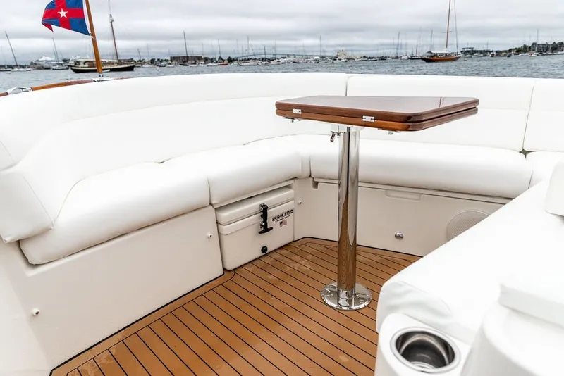 Slide: The Image of 2026 Hinckley Picnic Boat 39 interior with white seating and wooden table. - 22