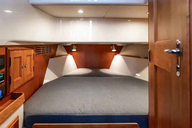 Slide: The Image of 2026 Hinckley Picnic Boat 39 cabin interior with cozy bed and wooden cabinetry. - 31