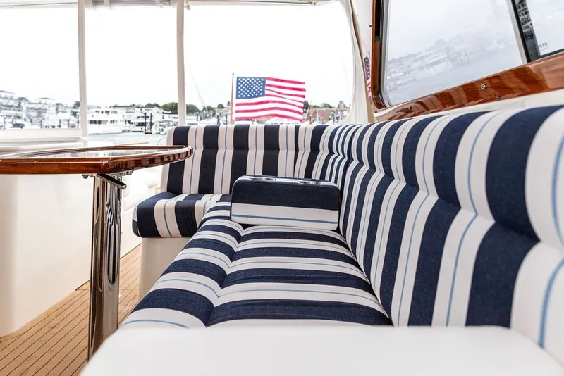 Slide: The Image of Elegant interior of 2026 Hinckley Picnic Boat 39 with striped seating and American flag. - 14