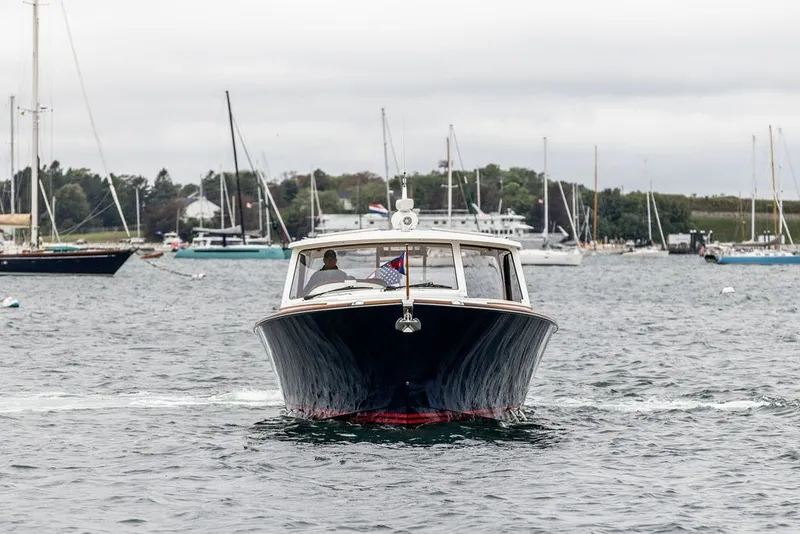 Slide: The Image of 2026 Hinckley Picnic Boat 39 cruising in a scenic harbor setting. - 2