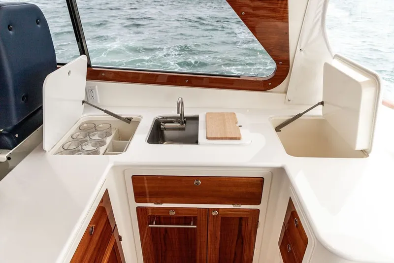 Slide: The Image of Interior of 2026 Hinckley Picnic Boat 39, featuring a sleek kitchenette with sink and storage. - 11