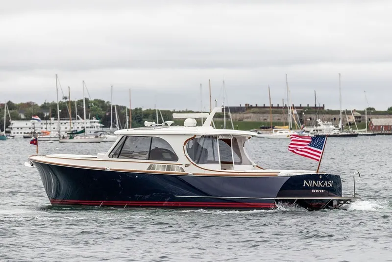Slide: The Image of 2026 Hinckley Picnic Boat 39 cruising in a harbor with American flag. - 1