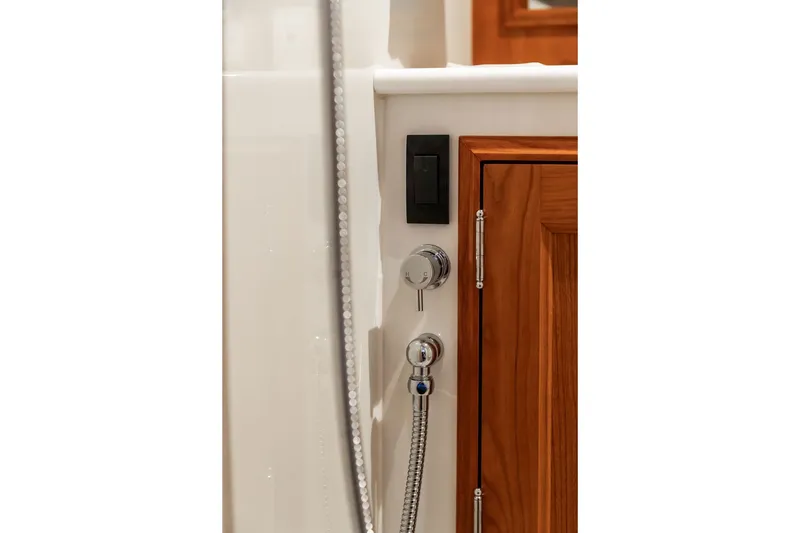 Slide: The Image of Interior detail of 2026 Hinckley Picnic Boat 39, featuring elegant wood cabinetry and chrome fixtures. - 32