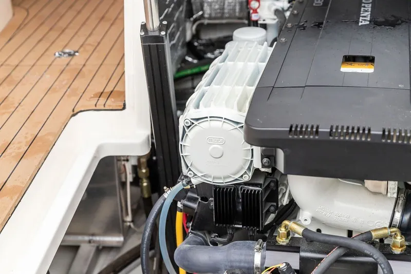 Slide: The Image of Engine compartment of 2026 Hinckley Picnic Boat 39, showcasing mechanical components and teak flooring. - 38