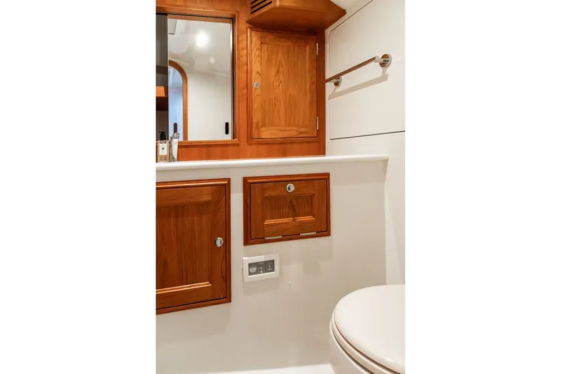 Slide: The Image of Hinckley Picnic Boat 39 (2026) bathroom with wooden cabinetry and modern fixtures. - 35