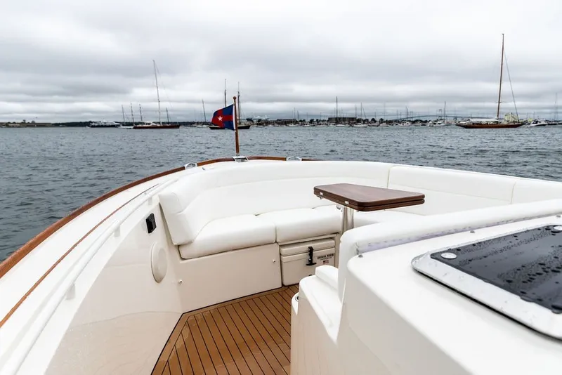 Slide: The Image of 2026 Hinckley Picnic Boat 39 with elegant seating and wooden deck on calm waters. - 17
