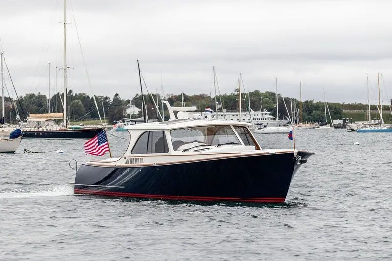 Slide: The Image of 2026 Hinckley Picnic Boat 39 cruising in a marina with American flag. - 3