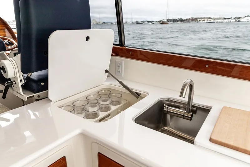 Slide: The Image of 2026 Hinckley Picnic Boat 39 interior with sink, storage, and ocean view. - 10