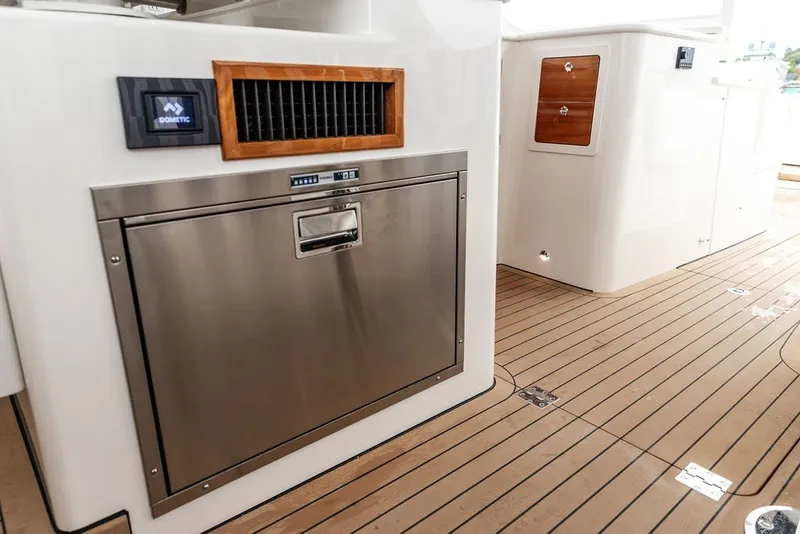Slide: The Image of 2026 Hinckley Picnic Boat 39 interior with stainless steel appliance and wooden flooring. - 13