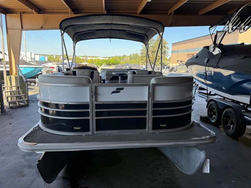 Slide: The Image of A 2017 Starcraft EX 20 C pontoon boat is parked in a covered area. - 1