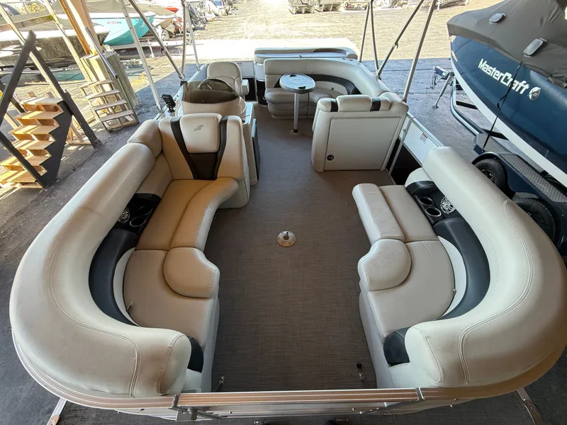 Slide: The Image of Interior view of a Starcraft EX 20 C pontoon boat with beige seating and a small table. - 6