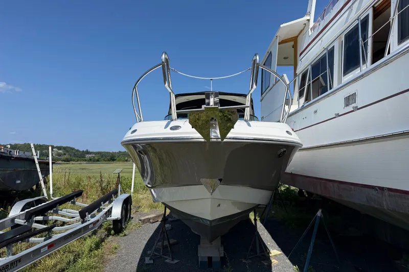 Slide: The Image of 2007 Chaparral 275 SSi boat on stands, next to a larger vessel, under clear blue sky. - 3