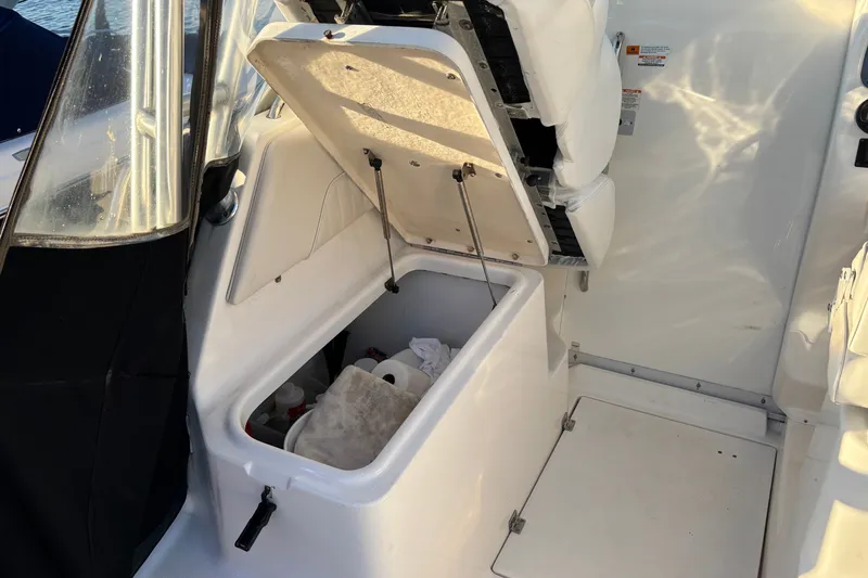 Slide: The Image of 2004 Robalo R245 Walkaround boat interior storage compartment open, showing contents. - 28