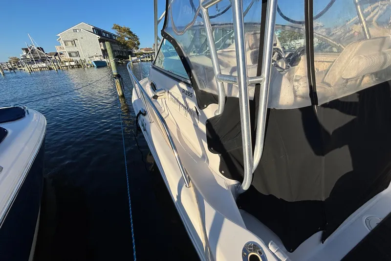 Slide: The Image of 2004 Robalo R245 Walkaround boat docked by waterfront homes. - 12