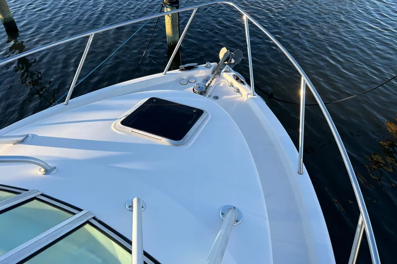 Slide: The Image of 2004 Robalo R245 Walkaround boat deck with railing, docked on calm water. - 4