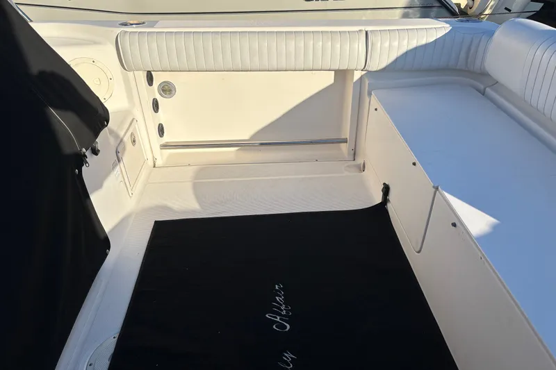 Slide: The Image of 2004 Robalo R245 Walkaround boat interior with white seating and black mat. - 30