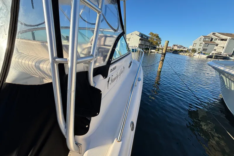 Slide: The Image of 2004 Robalo R245 Walkaround boat docked in a scenic waterfront marina. - 11