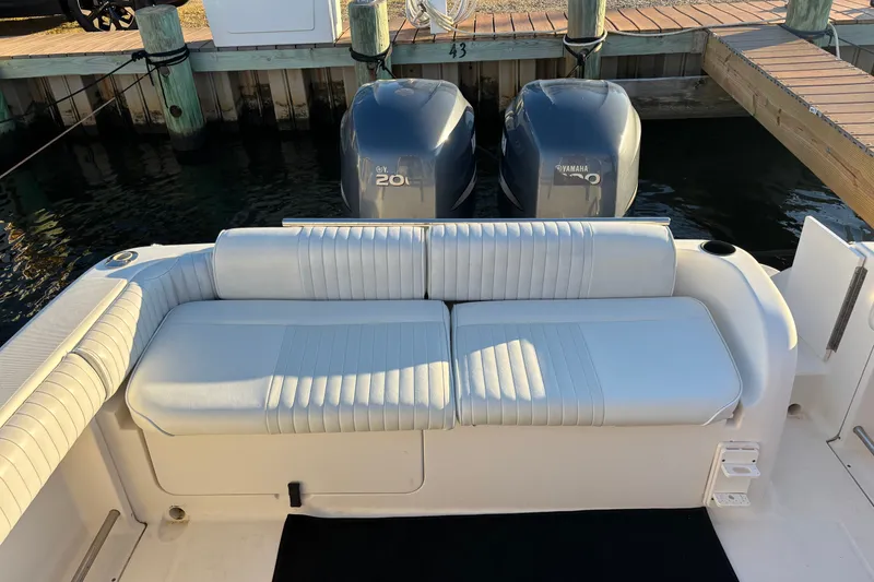 Slide: The Image of 2004 Robalo R245 Walkaround boat with dual Yamaha 200 engines and cushioned seating. - 26