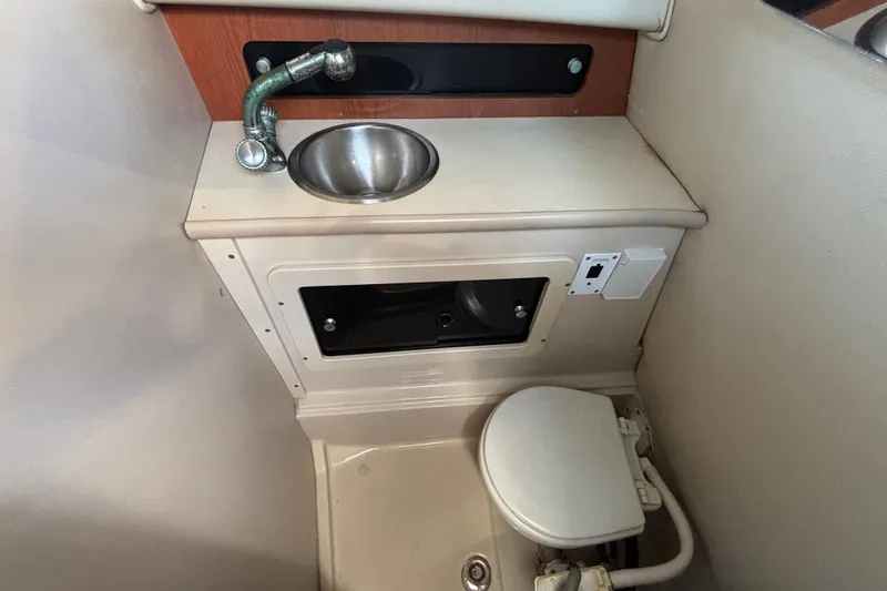 Slide: The Image of 2004 Robalo R245 Walkaround boat interior with sink and toilet. - 22