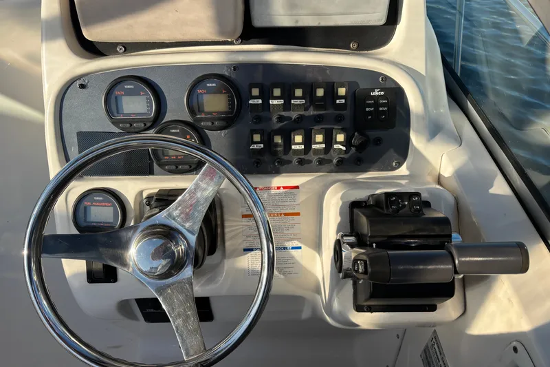 Slide: The Image of 2004 Robalo R245 Walkaround boat dashboard with steering wheel and control panel. - 7