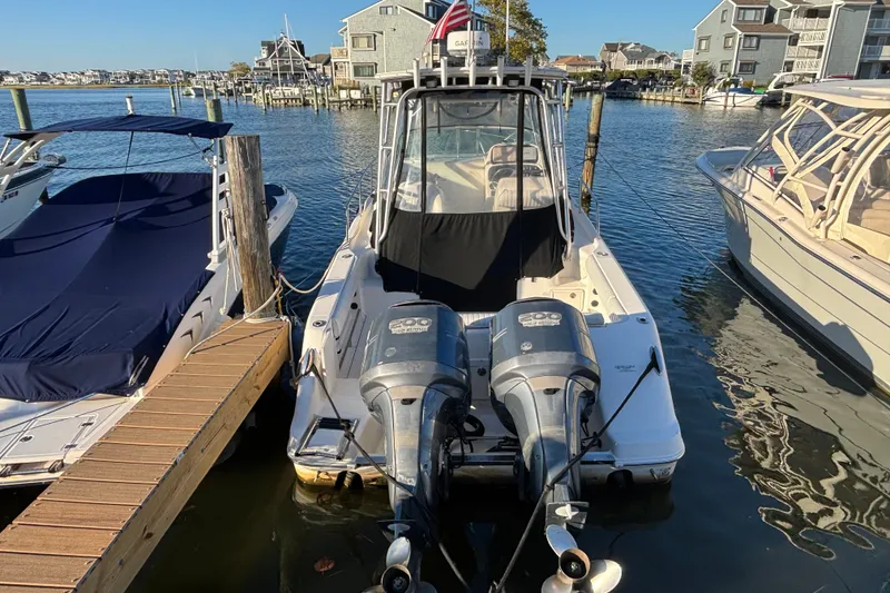 Slide: The Image of 2004 Robalo R245 Walkaround boat docked with twin engines, waterfront view. - 3