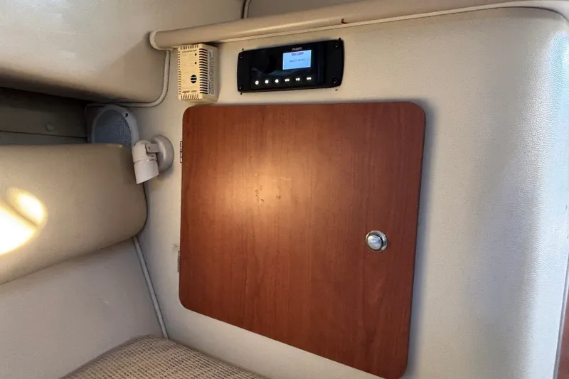 Slide: The Image of Interior of 2004 Robalo R245 Walkaround boat with wooden cabinet and control panel. - 20