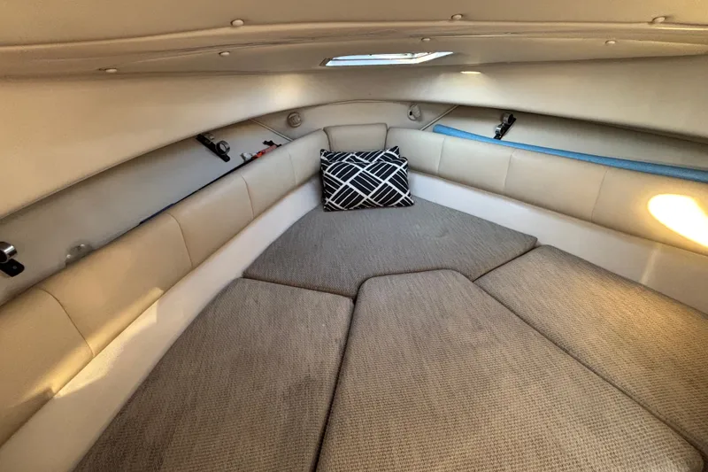 Slide: The Image of 2004 Robalo R245 Walkaround cabin interior with beige upholstery and patterned pillow. - 13