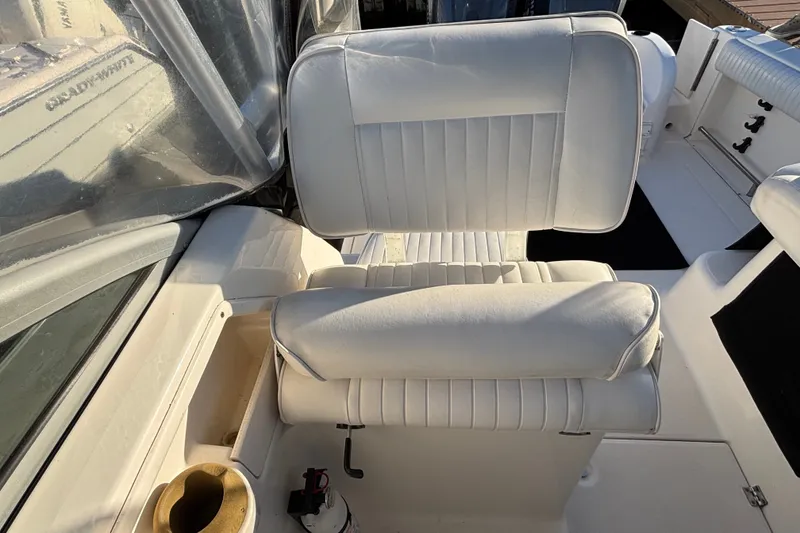 Slide: The Image of 2004 Robalo R245 Walkaround boat interior with white cushioned seating. - 24