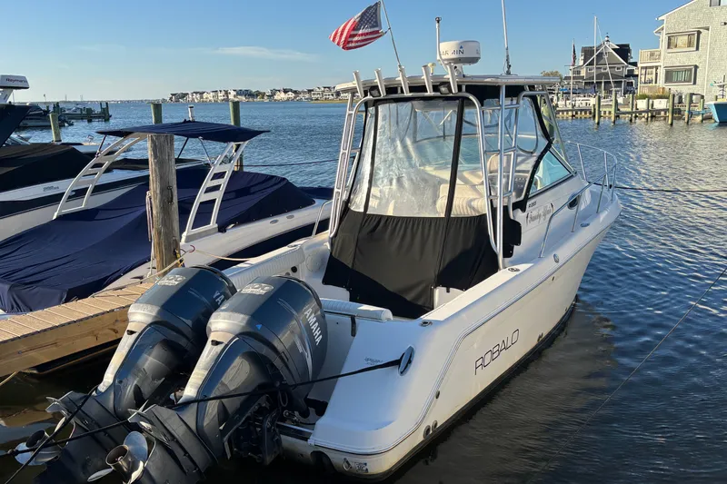 Slide: The Image of 2004 Robalo R245 Walkaround boat docked with twin Yamaha engines. - 1