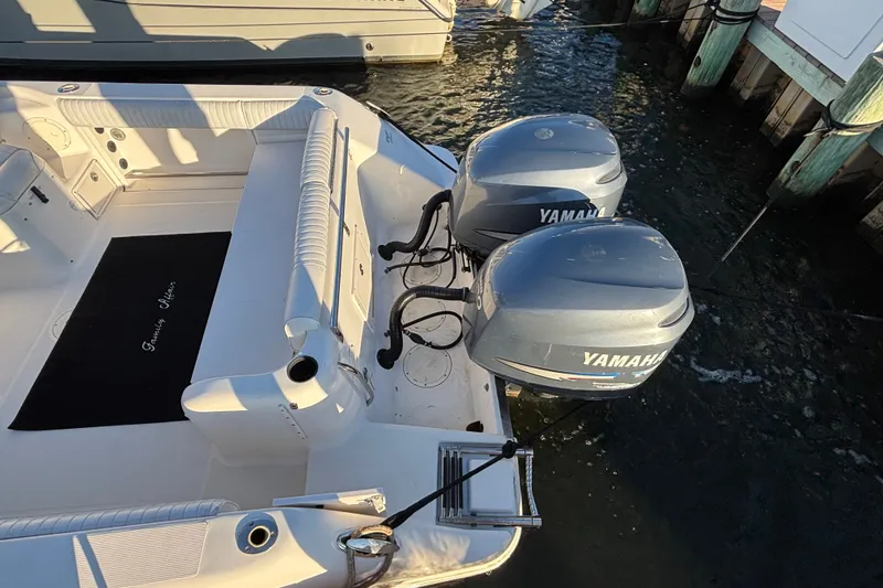 Slide: The Image of 2004 Robalo R245 Walkaround boat with twin Yamaha outboard engines docked. - 29