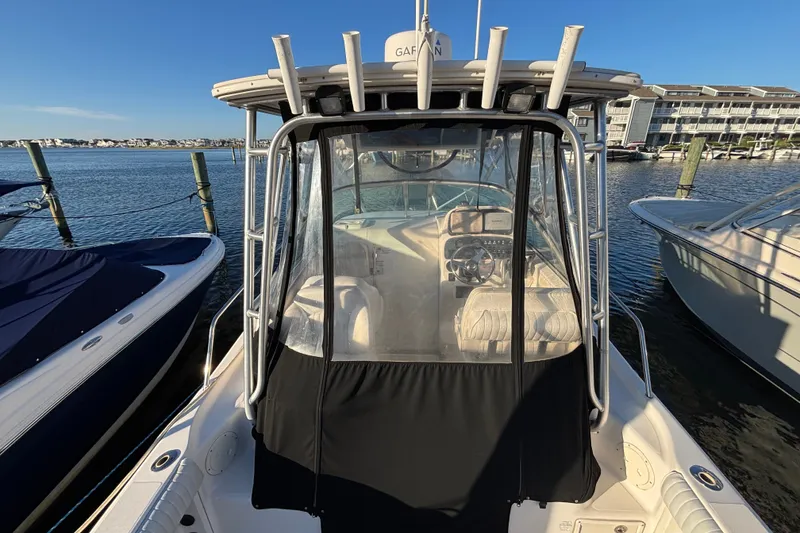 Slide: The Image of 2004 Robalo R245 Walkaround boat docked at marina, clear sunny day. - 32