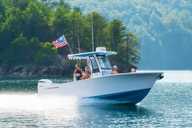 The Image of 2027 Sportsman Heritage 231 Center Console boat cruising on a scenic lake. - 0