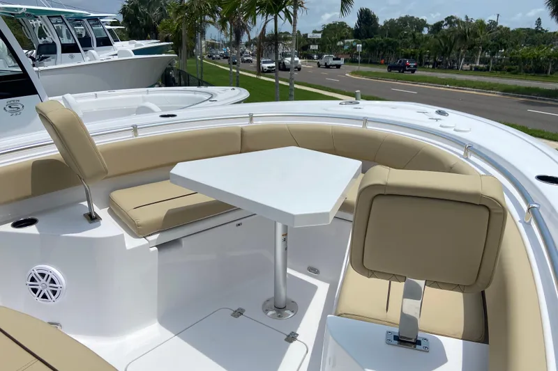 Slide: The Image of 2027 Sportsman Heritage 231 Center Console boat with beige seating and a white table. - 30