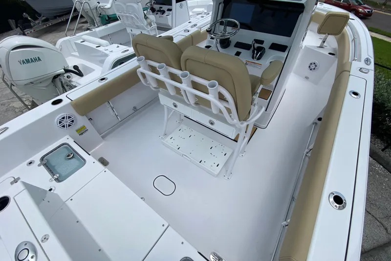 Slide: The Image of 2027 Sportsman Heritage 231 Center Console boat interior with beige seating and Yamaha engine. - 2
