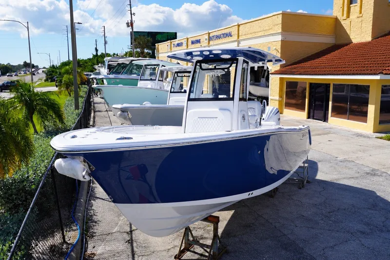 The Image of 2027 Sportsman Open 232 Center Console boat displayed outdoors on a sunny day. - 0