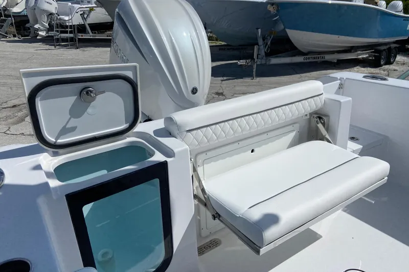 Slide: The Image of 2027 Sportsman Open 232 Center Console boat interior with cushioned seating and storage compartment. - 5